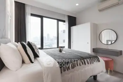 Modern bedroom with city view, stylish decor, and natural light.