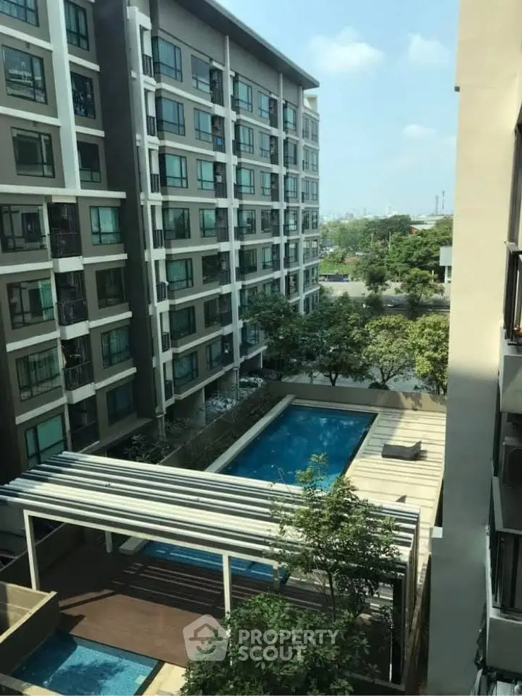 Modern apartment complex with pool and lush greenery view