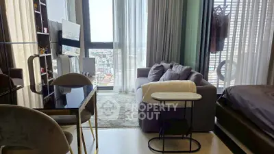 Modern living room with city view, featuring sleek furniture and floor-to-ceiling windows.