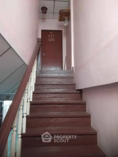 Charming staircase leading to a wooden door in a cozy residential property.