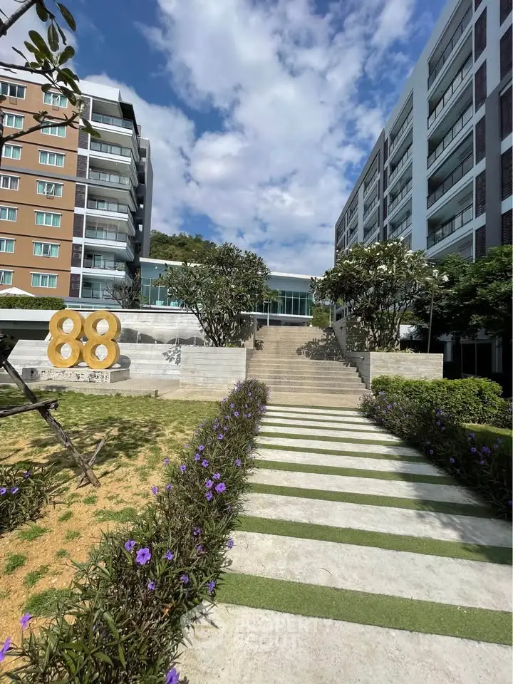 Modern apartment building with landscaped garden and clear blue sky.