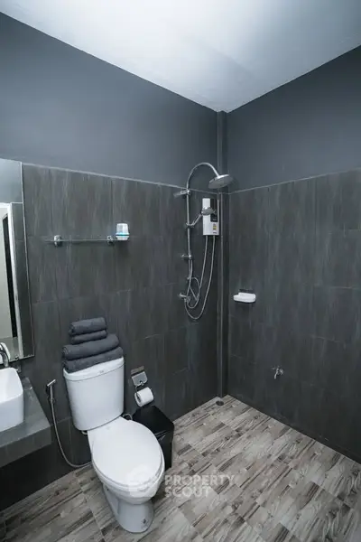 Modern bathroom with sleek design and contemporary fixtures, featuring a shower and toilet.