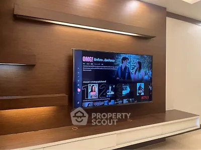 Modern living room with built-in wooden TV unit and ambient lighting