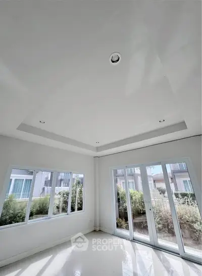 Bright and spacious room with large windows and garden view