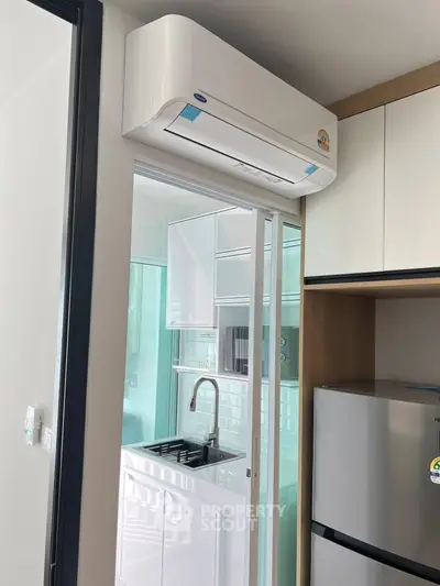 Modern kitchen with sleek appliances and air conditioning unit, featuring a compact and efficient design.