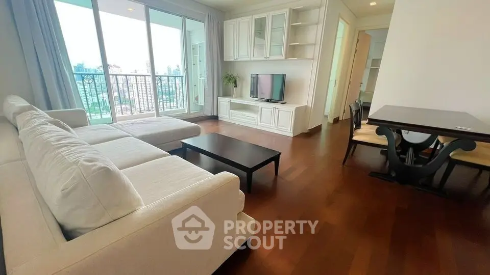 Spacious living room with large windows and elegant furnishings in a modern apartment.