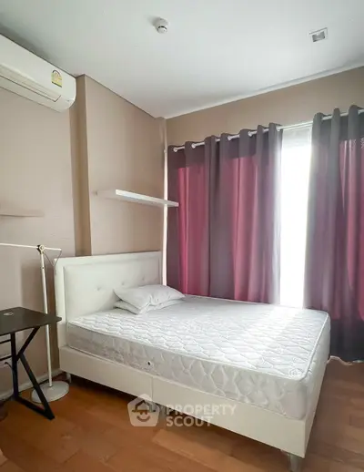 Cozy bedroom with natural light, featuring a single bed and modern decor.