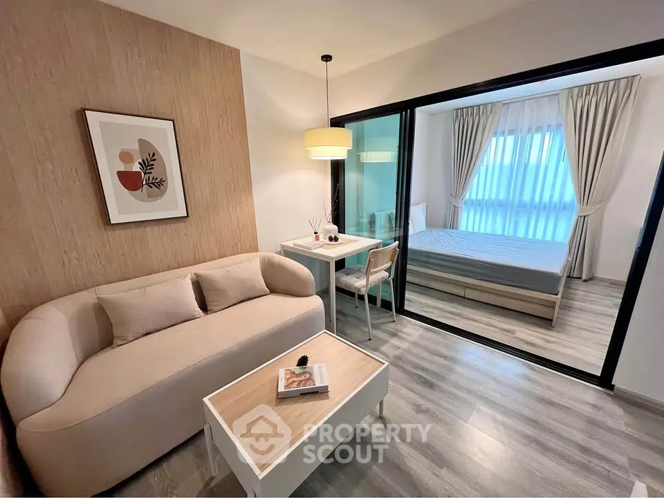 Modern living room with cozy sofa and stylish decor adjacent to a bright bedroom.