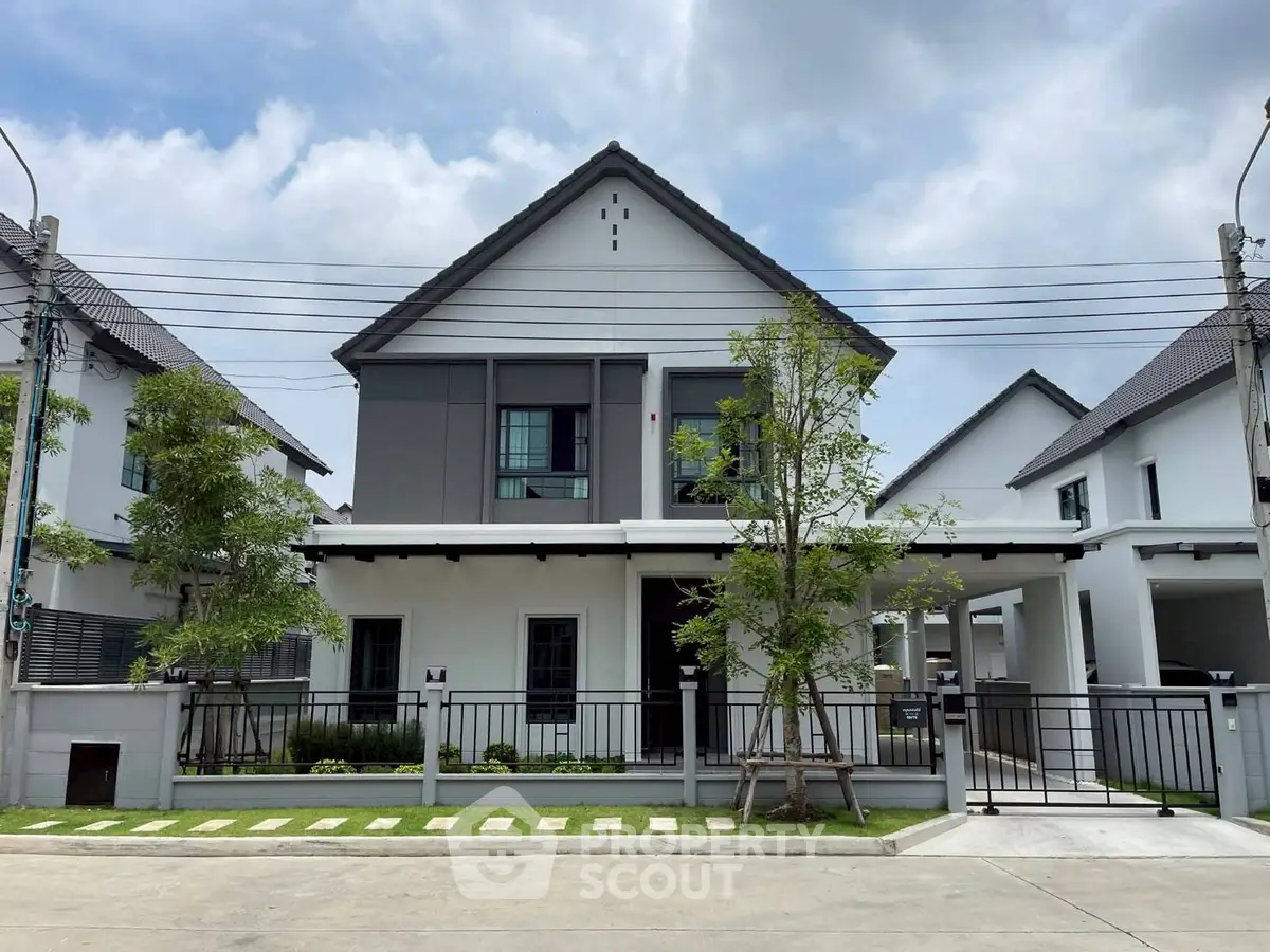 Modern two-story house with sleek design and landscaped front yard