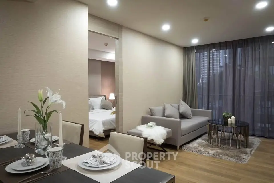 Modern open-plan living room with elegant dining area and cozy bedroom view.