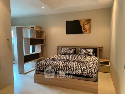 Spacious modern bedroom with stylish decor and ample natural light