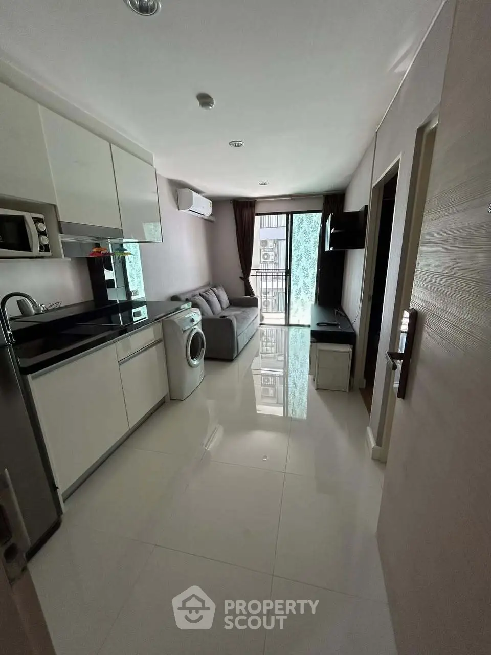 Modern apartment with sleek kitchen, cozy living area, and balcony access, perfect for urban living.