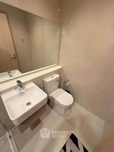 Modern bathroom with sleek fixtures and large mirror