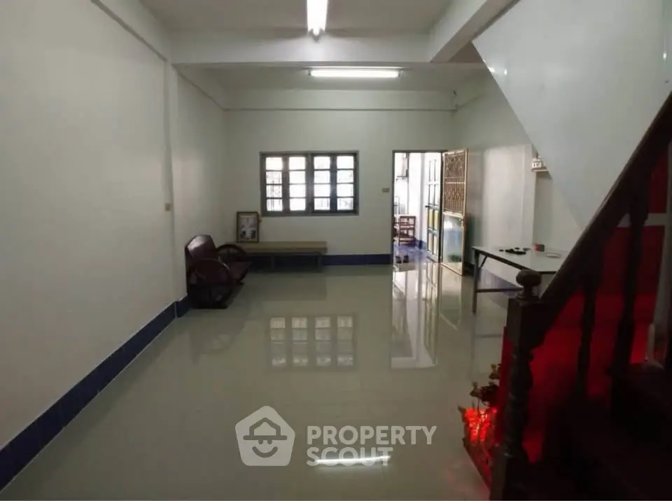 Spacious living room with tiled flooring and natural light, ideal for family gatherings.