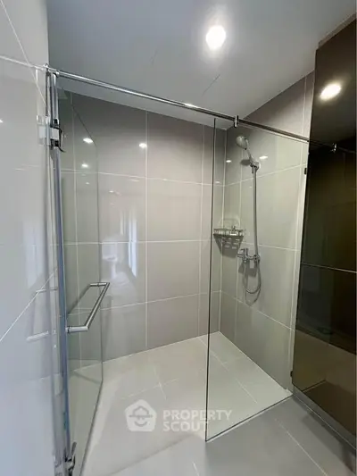 Modern bathroom with sleek glass shower enclosure and contemporary fixtures.