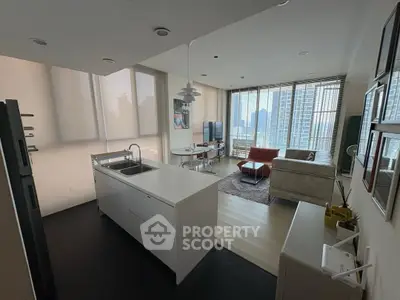 Modern open-plan living room with kitchen, featuring sleek design and city view.