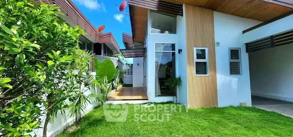 Modern house exterior with lush garden and sleek architectural design.