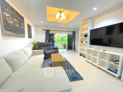 Spacious living room with modern decor and large TV, perfect for relaxation.