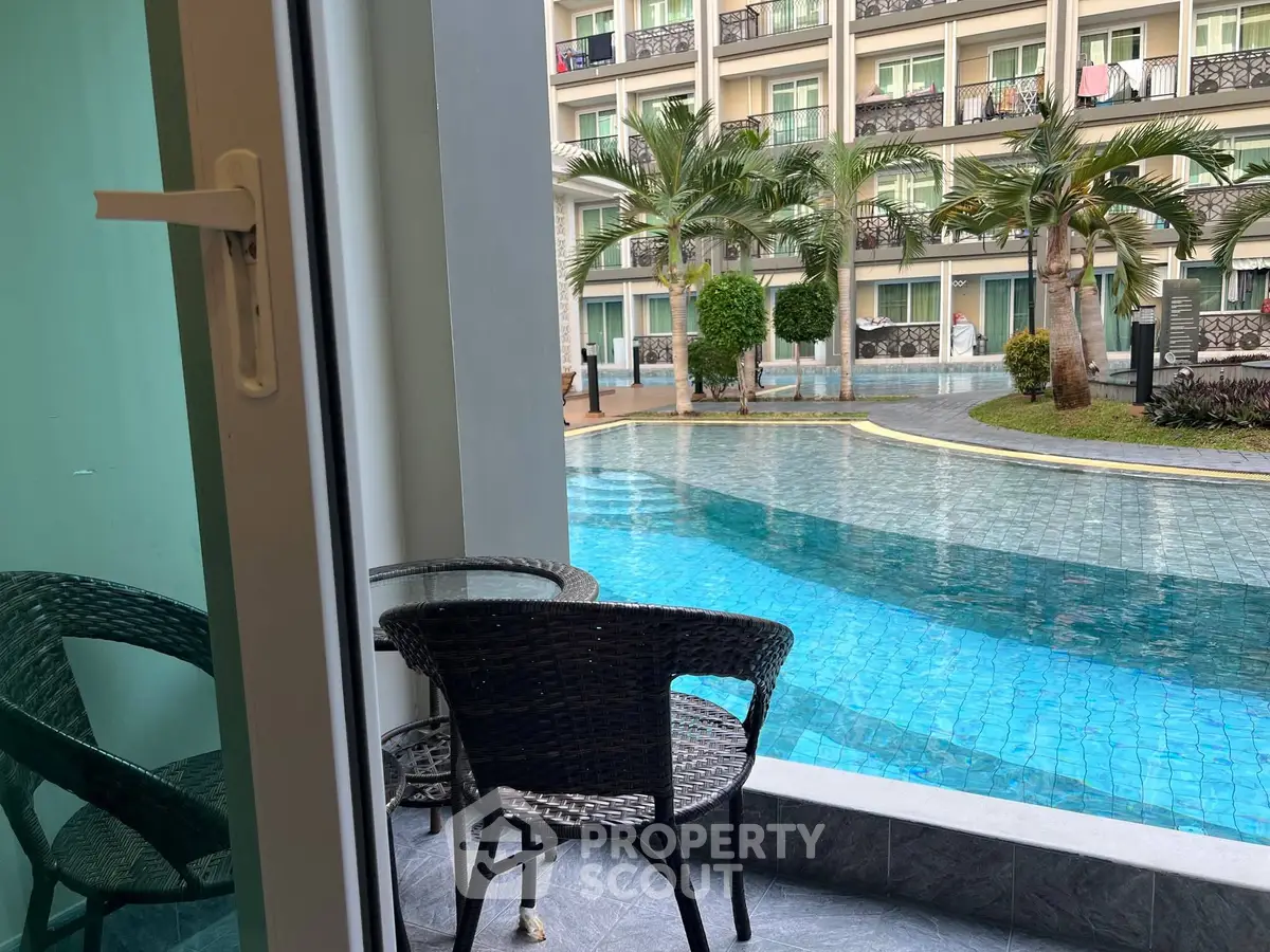 Luxurious poolside view from a stylish balcony in a modern apartment complex.