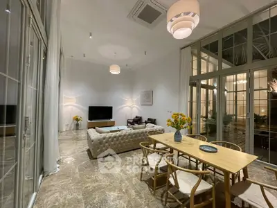 Luxurious open-plan living room with elegant decor and large windows, perfect for modern living.