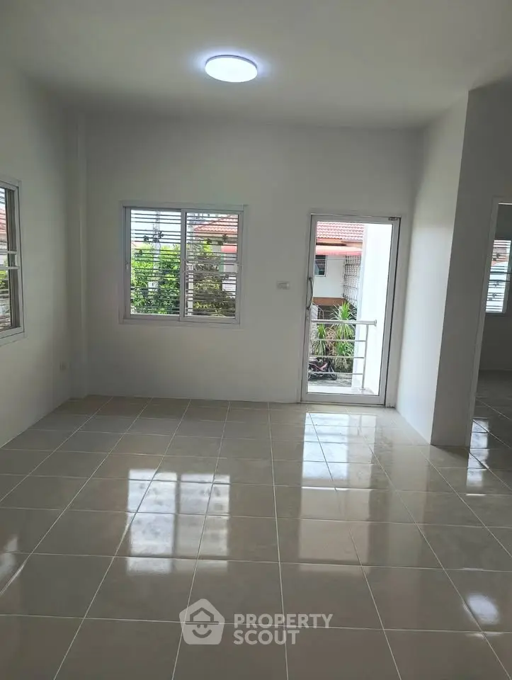 Bright and spacious living room with large windows and balcony access, perfect for natural light lovers.