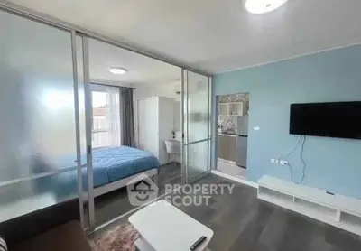 Modern apartment with glass partition, cozy living area, and sleek bedroom design.