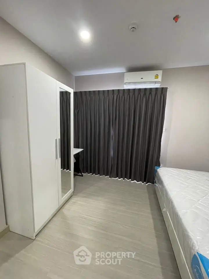 Modern bedroom with sleek wardrobe and air conditioning in a stylish apartment.