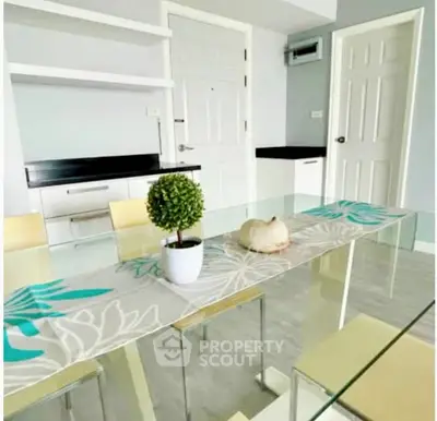 Modern dining area with glass table and stylish decor in a contemporary apartment.