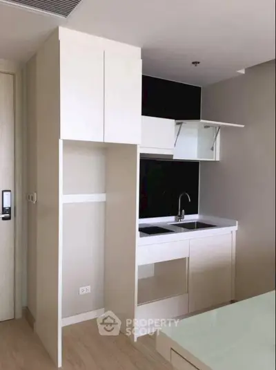 Modern compact kitchen with sleek cabinetry and built-in appliances