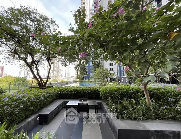 Lush garden area with seating in modern residential complex, perfect for relaxation.