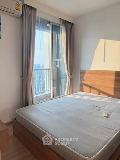 Bright bedroom with large window and city view, featuring a comfortable bed and modern decor.