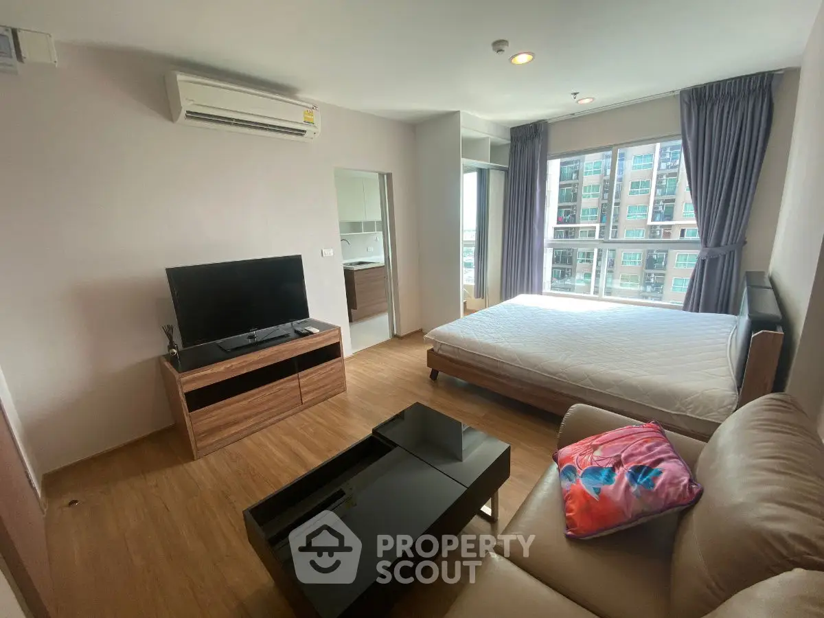 Modern bedroom with large window, TV, and air conditioning in a stylish apartment.