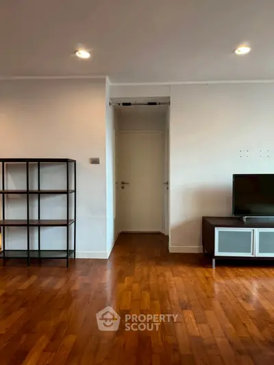 Spacious living room with wooden flooring and modern TV unit