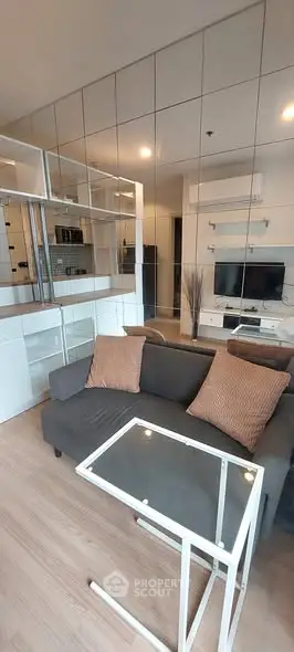 Modern living room with sleek design and mirrored wall for spacious feel