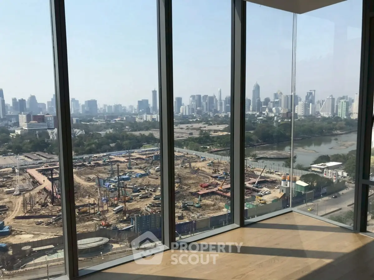 Stunning cityscape view from modern high-rise apartment with floor-to-ceiling windows.