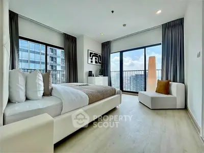 Modern bedroom with large windows and city view in a high-rise apartment.