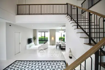 Spacious modern living room with elegant staircase and dining area