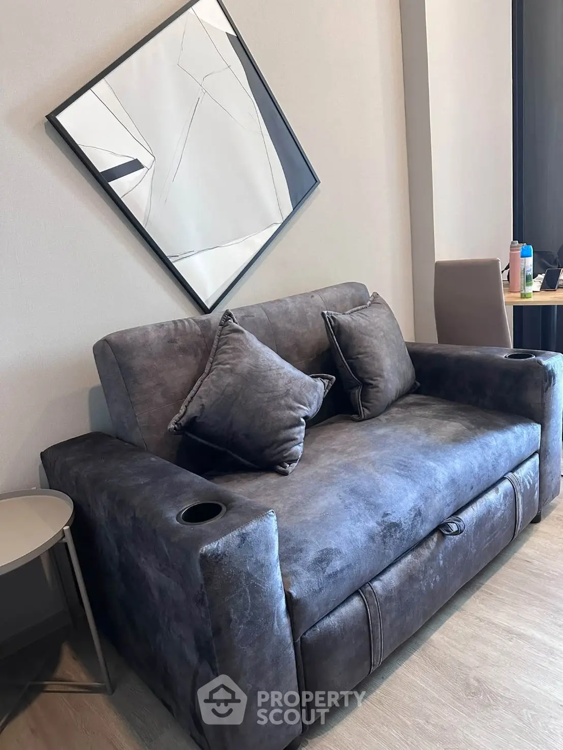 Stylish modern living room with plush sofa and abstract art, perfect for cozy relaxation.