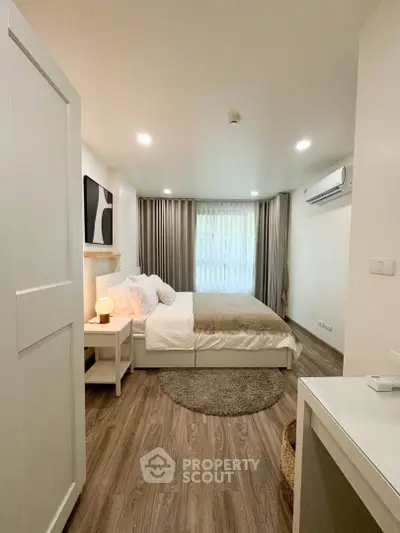 Modern bedroom with cozy decor and natural light, featuring a stylish bed and elegant flooring.