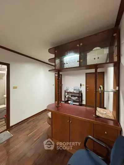 Charming interior with wooden cabinetry and elegant glass display, perfect for cozy living.