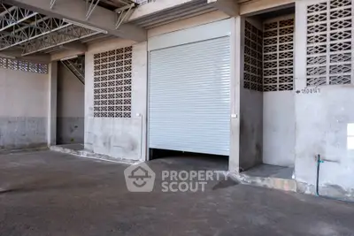 Industrial warehouse with large roller door and concrete flooring, ideal for storage or distribution.