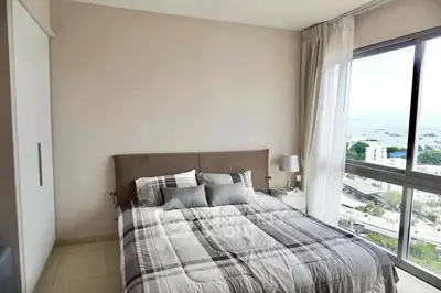 Bright bedroom with large window offering stunning ocean view