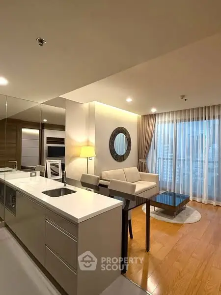Modern living room with open kitchen and city view, featuring sleek design and elegant decor.
