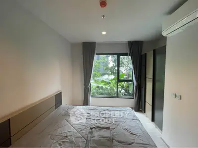 Modern bedroom with large window and garden view, featuring sleek design and natural light.