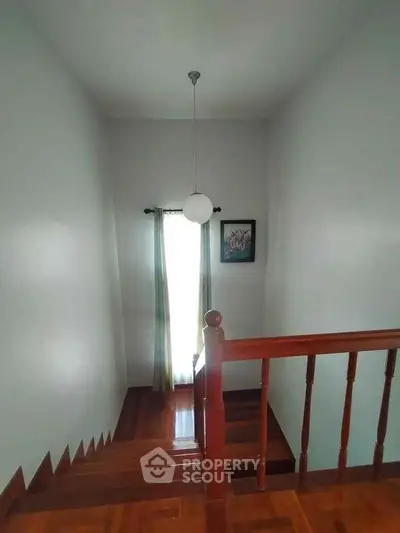 Elegant wooden staircase with modern lighting and framed art