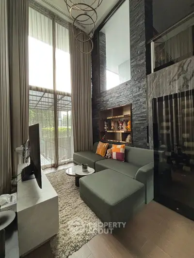 Modern living room with high ceilings and large windows, featuring a stylish sofa and elegant decor.