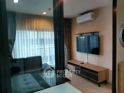 Modern living room with sleek furniture and wall-mounted TV, featuring large windows and natural light.