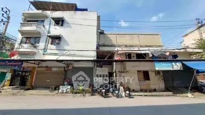 Street view of mixed-use building with retail shops and residential units, showcasing urban living.