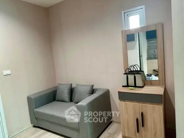 Cozy living room with modern gray sofa and stylish wooden cabinet with mirror.