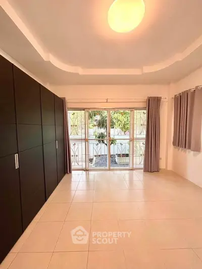 Spacious bedroom with large windows and built-in wardrobe, offering natural light and modern design.